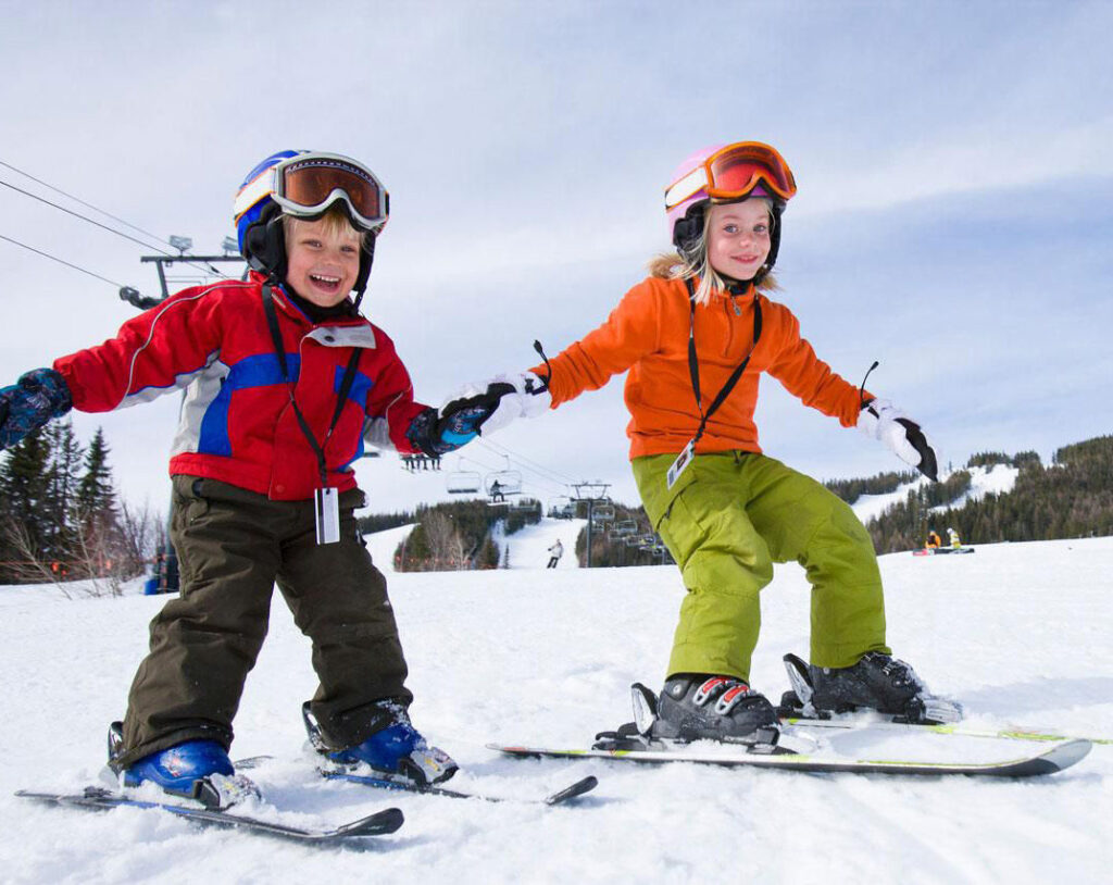 skids holding hands while skiing